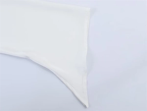 Nahaufnahme des asymmetrischen Saums der weißen Satinbluse mit feinen Nähten am Rand
