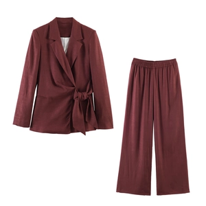 Detail van bordeauxrood tweedelig pak met blazer met zijstrik en wijde pantalonbroek