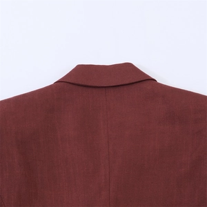 Macrodetail van de wijnrode blazer kraag met elegante visgraat woltextuur