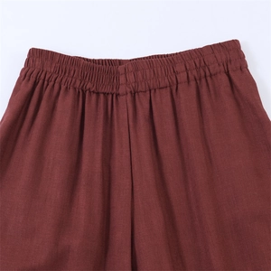Detail van de bordeauxrode broek met elastische tailleband en structuur van de stof