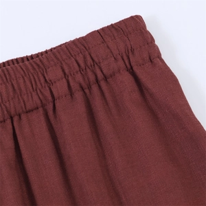 Detail van de bordeauxrode getextureerde broek met elastische taille en keperbinding