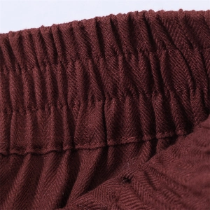 Macro-opname van de wijnrode broek met elastische geplooide tailleband en textuur