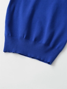 Detailed view of royal blue knit sweater featuring ribbed hem and fine fabric texture