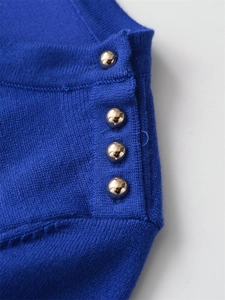 Close-up of navy blue knit fabric featuring elegant gold buttons on the side seam
