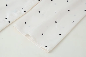 Dettaglio dei polsini della camicia in raso a pois con cuciture di qualità e tessuto liscio