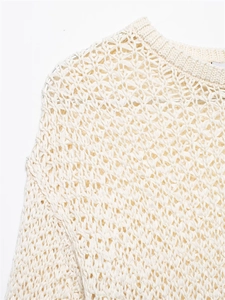 Dettaglio della maglia traforata geometrica con girocollo a costine in bianco crema chic