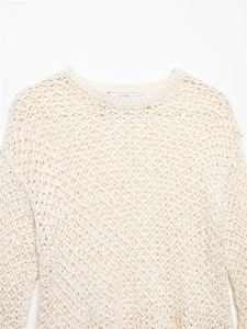 Dettaglio del maglione a maglia all'uncinetto crema con trama traforata e scollo rotondo