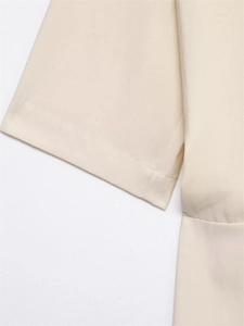 Close-up detail of smooth cream pleated midi dress sleeves with premium stitching