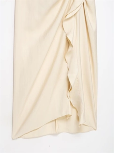 Detail shot of draped ruffle design on cream satin midi dress with silky texture