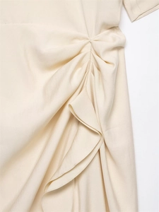 Close-up detail of side ruching and ruffled edges on an ivory midi spring dress
