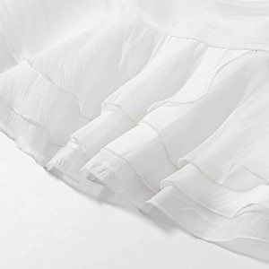 Elegante completo bianco due pezzi con gonna, dettagli a balze e trama in tessuto chiffon