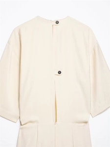 Detail of elegant back slit with black buttons and zipper on the cream pleated midi dress