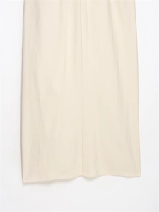 Detail of the clean-cut hemline and draped texture on an ivory midi dress
