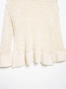 Dettaglio del top in maglia all'uncinetto crema con intricati motivi geometrici traforati