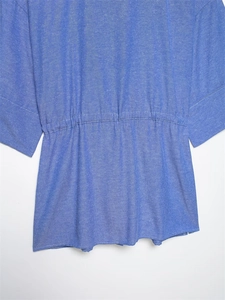 Detail of blue casual linen-textured shirt showing the cinched waist and fabric weave