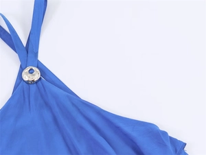 Detail van een koningsblauwe jurk met een gehamerde zilveren metalen ring op de schouder