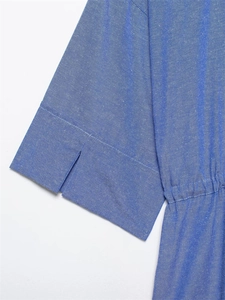 Detail of blue cotton-linen shirt featuring unique V-slit cuffs and pleated waistline design