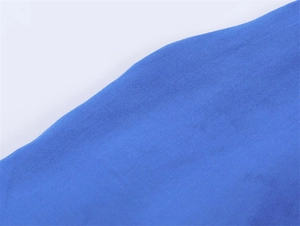 Macro-opname van helder koningsblauw gebreid textiel met gedetailleerde textuur en stof