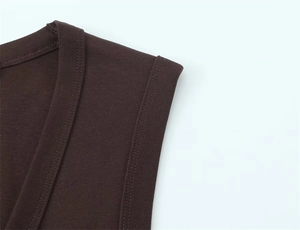 Detailed close-up of dark brown sleeveless top with ribbed knit crewneck and armhole