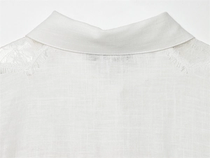Dettaglio dell'elegante pizzo a ciglia sul colletto e sulla spalla di una camicia bianca