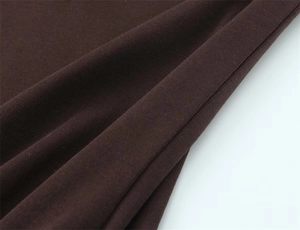 Detailed close-up of dark brown knit fabric showing soft texture and fine ribbed patterns