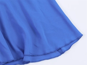 Gedetailleerde close-up van de dubbelgestikte zoom van een koningsblauwe chiffon maxi-jurk