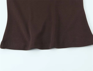 Detail view of the double-stitched hem on a brown sleeveless V-neck knit T-shirt