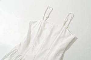 Detalle de vestido blanco con tirantes ajustables y costuras caladas en el pecho