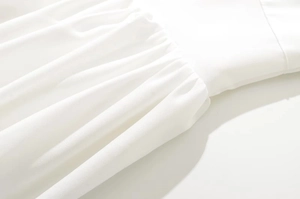 Detalle de la cintura plisada en un vestido midi vintage francés blanco mostrando la textura