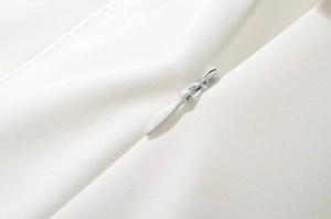 Primer plano de la cremallera invisible y la textura de sarga fina en el vestido blanco
