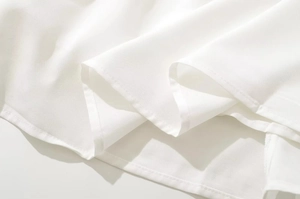 Primer plano detallado del dobladillo del vestido blanco con costuras de alta calidad