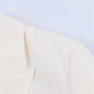 Nahaufnahme der cremefarbenen Textur und Reversnaht einer eleganten Damenjacke