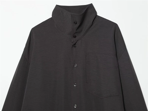 Detail of high-neck dark grey shirt with cargo chest pocket and button closure