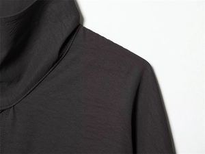 Detailed close-up of dark grey shirt shoulder seam with high-quality stitching and texture