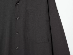 Close-up of charcoal black shirt showing chest pocket, side seams and matching buttons