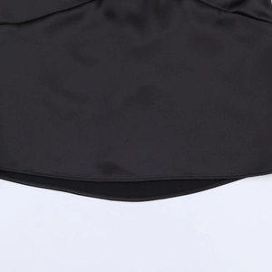 Close-up of black satin camisole hem showing smooth fabric and neat double-stitching