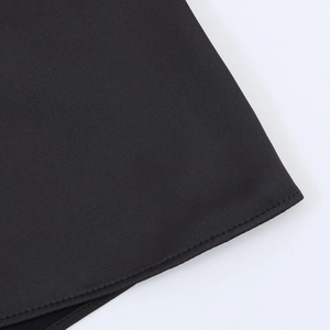 Detail shot of the precise double-needle hem stitching on black satin halter top