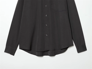 Detail of charcoal grey long sleeve shirt with chest pocket and curved hemline