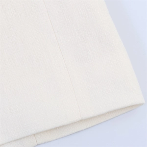 Detailaufnahme der hochwertigen beigen Stoffstruktur und der präzisen Nähte der Bluse