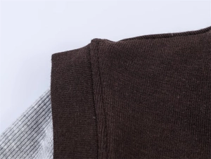 Nahaufnahme eines braunen Strick-T-Shirts mit grauen Rippstrick-Details am Ärmelansatz
