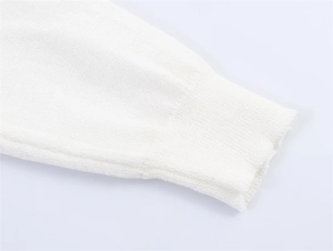 Detailansicht der fein gerippten Bündchen an einem weißen leichten Strickpullover