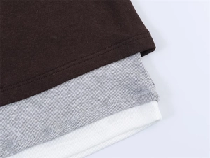 Detail von körpernahen Langarmshirts mit braunen, grauen und weißen Stoffstrukturen