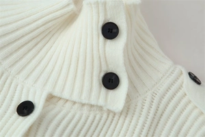 Close-up of white ribbed knit cardigan featuring turtleneck and decorative black buttons