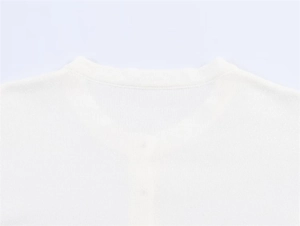 Detailaufnahme der glatten Nähte und der hochwertigen Stricktextur am weißen Halsausschnitt