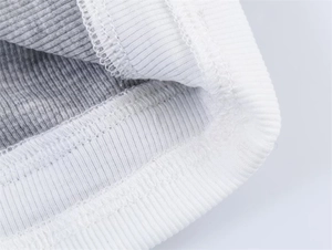 Makroaufnahme von grauem Rippstrickstoff mit weißem Kontrastausschnitt und Nähten