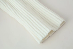 Close-up of classic rib-knit cuff details on a premium white knitted cardigan sweater