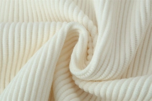 Macro view of creamy off-white ribbed knit fabric texture showing soft vertical grooves