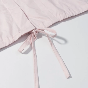 Gros plan sur le tissu rose clair avec cordon de serrage et coutures précises