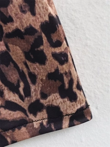 Nahaufnahme des Leopardenmusters mit präziser schwarzer Doppelnaht am Saum des Kleides