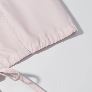 Détail de manche de chemisier rose clair avec cordon de serrage et tissu lisse cousu